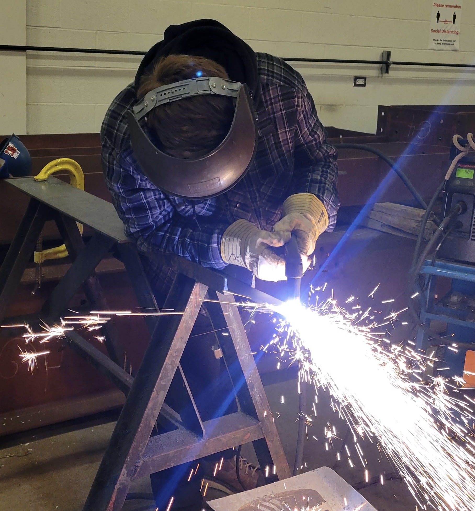 Three workers in safety gear collaborate on a construction site, adjusting rebar and preparing for concrete pouring under a clear blue sky.